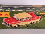an old red and white toy car sitting on top of a box