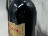 a bottle of wine sitting on a table next to a bag
