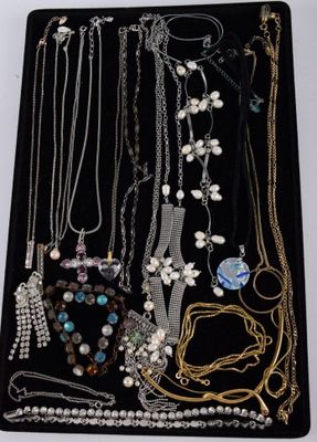 many different necklaces and bracelets displayed in a display case