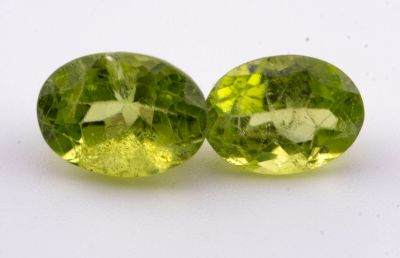 deux péridotites vertes de forme ovale sur une surface blanche