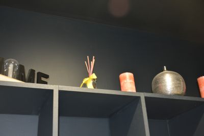 a shelf with candles, candles, and vases on it