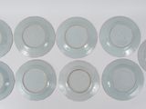 six white plates with gold rims on a white surface