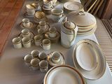 une longue table sur laquelle sont disposées de nombreuses assiettes et bols
