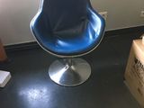 une chaise bleue dans une pièce où il y a des cartons par terre