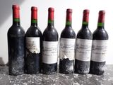 six bouteilles de vin rouge sont alignées sur une table