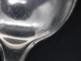 a silver spoon with a heart on it sitting on a table