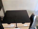 a black table with two drawers next to a chair
