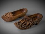 pair of carved wooden clogs with flowers on them