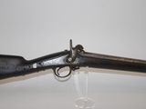 an old gun with a wooden handle on a white surface