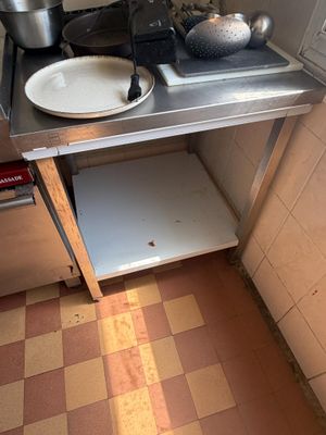 a small kitchen with a stove, sink, and pots on the counter