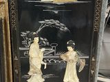 une photo d'un tableau noir et or accroché au mur