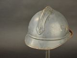 a silver helmet on a metal stand on a gray background