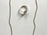 necklace, ring, and earring set on a white surface