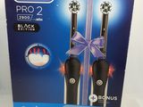 two black electric toothbrushes in a box on a white surface