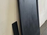 a black board leaning against a wall next to a white wall