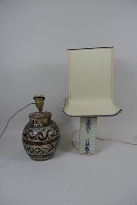 une lampe posée à côté d'un vase sur une table