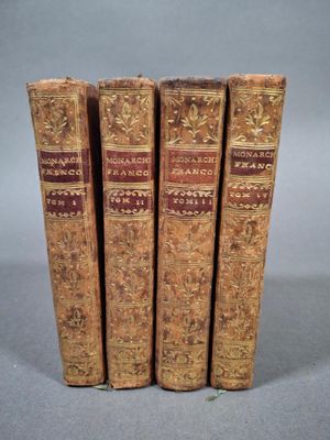 trois vieux livres posés l'un sur l'autre sur une table