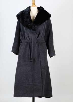 un manteau noir à col de fourrure sur un mannequin