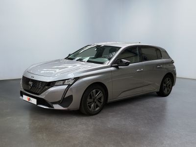une voiture argentée garée dans une pièce aux murs blancs