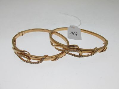 paire de bracelets rigides de couleur dorée, ornés de pierres transparentes de chaque côté