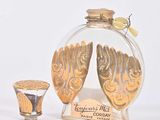 une petite bouteille en verre ornée d'un motif doré
