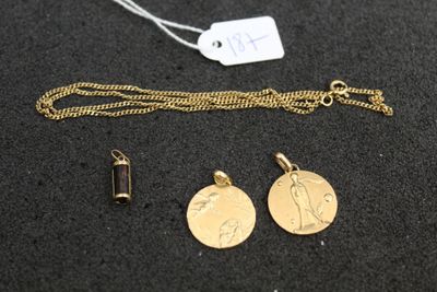 a close up of a gold necklace with two charms on a black surface