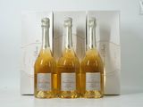 trois bouteilles de vin sont posées devant une boîte blanche