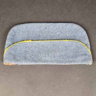 un gros plan d'un étui gris et jaune posé sur une surface marron