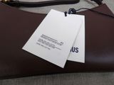 a brown purse with a tag on it sitting on a couch