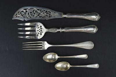 cinq cuillères et une fourchette sur une table noire