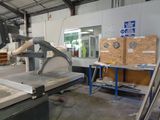 a machine that is cutting a piece of wood in a factory