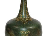 un vase vert orné d'un motif doré