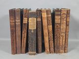 several old books are lined up in a row on a table