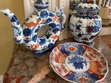 trois théières bleues et blanches et une assiette posées sur une table