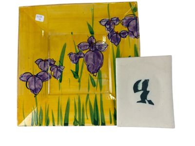 des fleurs violettes sur une assiette jaune, à côté d'une assiette blanche sur laquelle est représentée une fleur violette