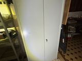 a white cabinet in the corner of a room