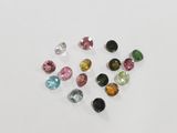 a bunch of different colored gems on a white surface