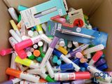 une boîte en carton remplie de feutres et de stylos de différentes couleurs