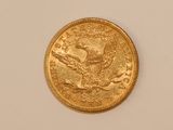 a close up of a gold coin on a white surface