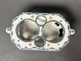 a small white and blue vase with two holes in it