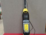 un aspirateur jaune et noir posé sur une table rouge