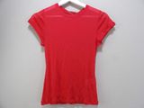 a red t - shirt hanging on a hanger against a white wall