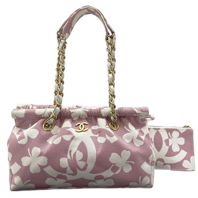 un gros plan sur un sac à main rose et blanc muni d'une chaîne dorée
