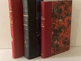 trois livres posés sur une table blanche