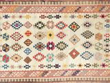 un tapis ancien aux motifs multicolores sur fond blanc
