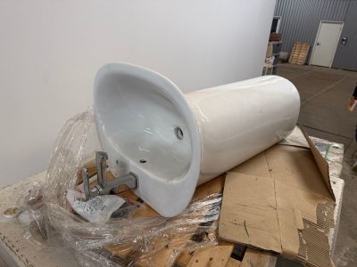 a white urinal sitting on top of a pallet in a warehouse