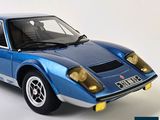 a blue model of a sports car on a white surface