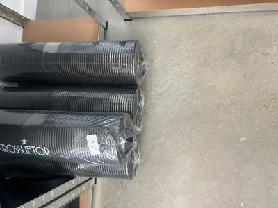 trois rouleaux de plastique noir posés par terre