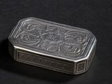 une vieille boîte en argent posée sur une surface noire
