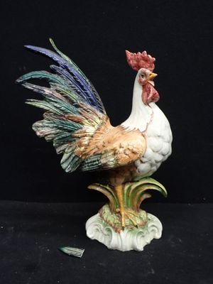a figurine of a rooster on a black background